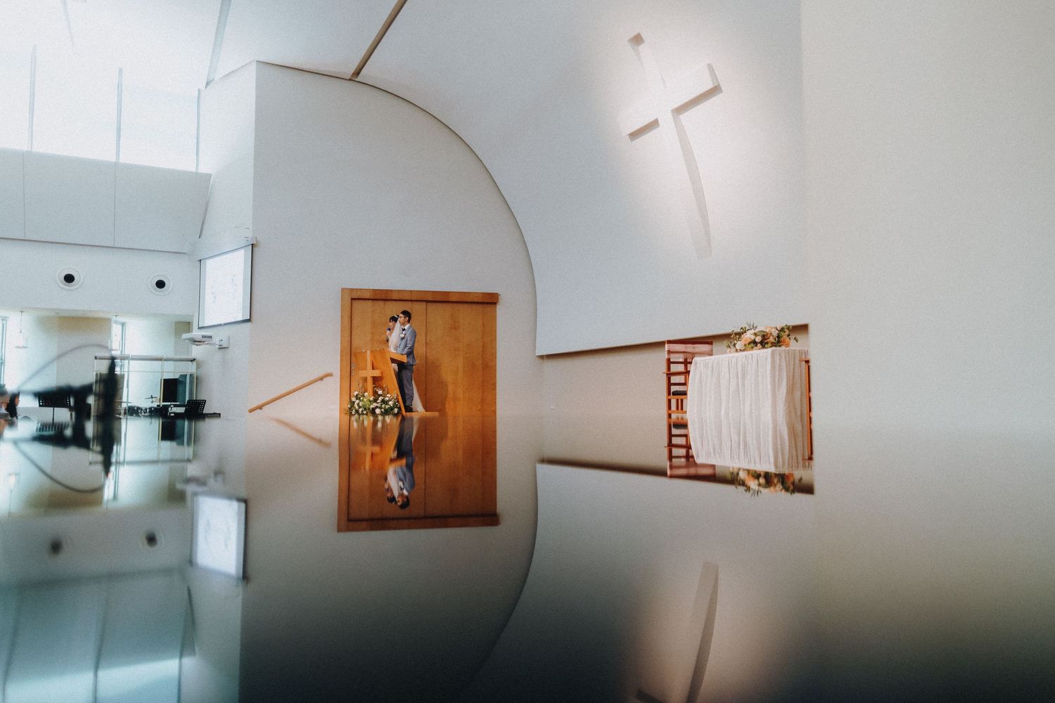 Silhouetted figure on ladder art installation arranged across multiple frames in minimalist gallery space.
