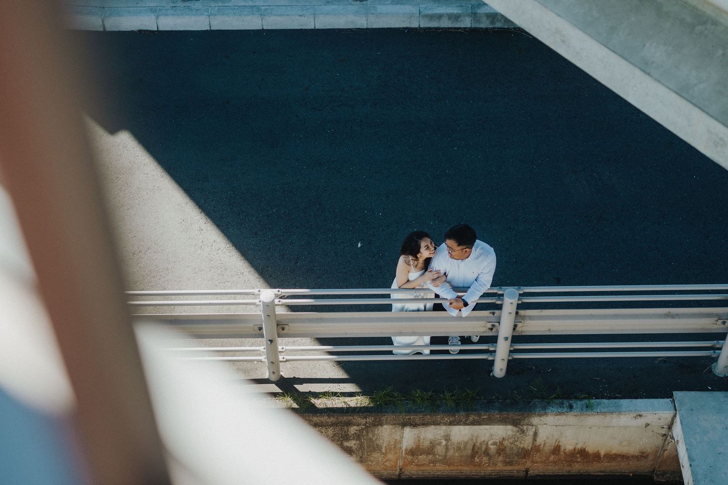Aerial view of a couple sharing an intimate moment on urban architecture.