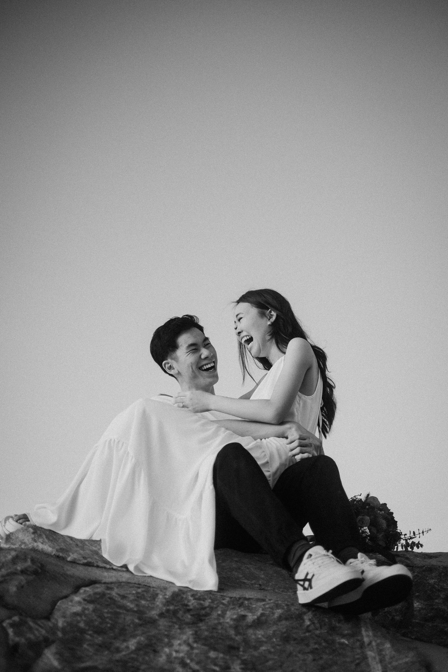 Black and white romantic photo sequence showing couple embracing on ground with dramatic shadows and angles.