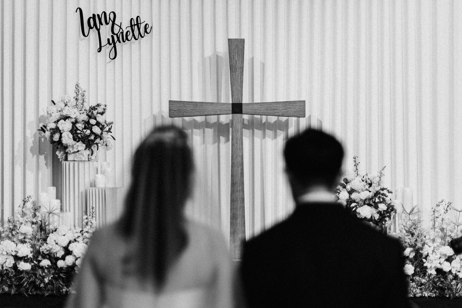 Wedding reception venue with white striped walls and floral decorations.