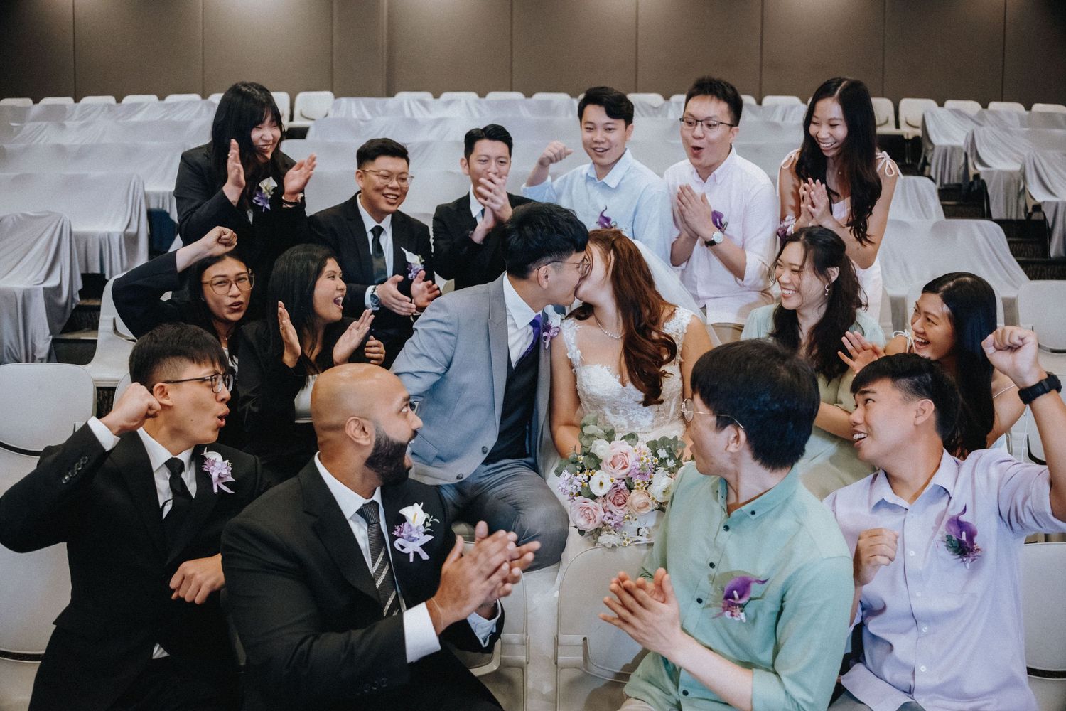 Wedding guests celebrate during a reception with joyful expressions and festive atmosphere.