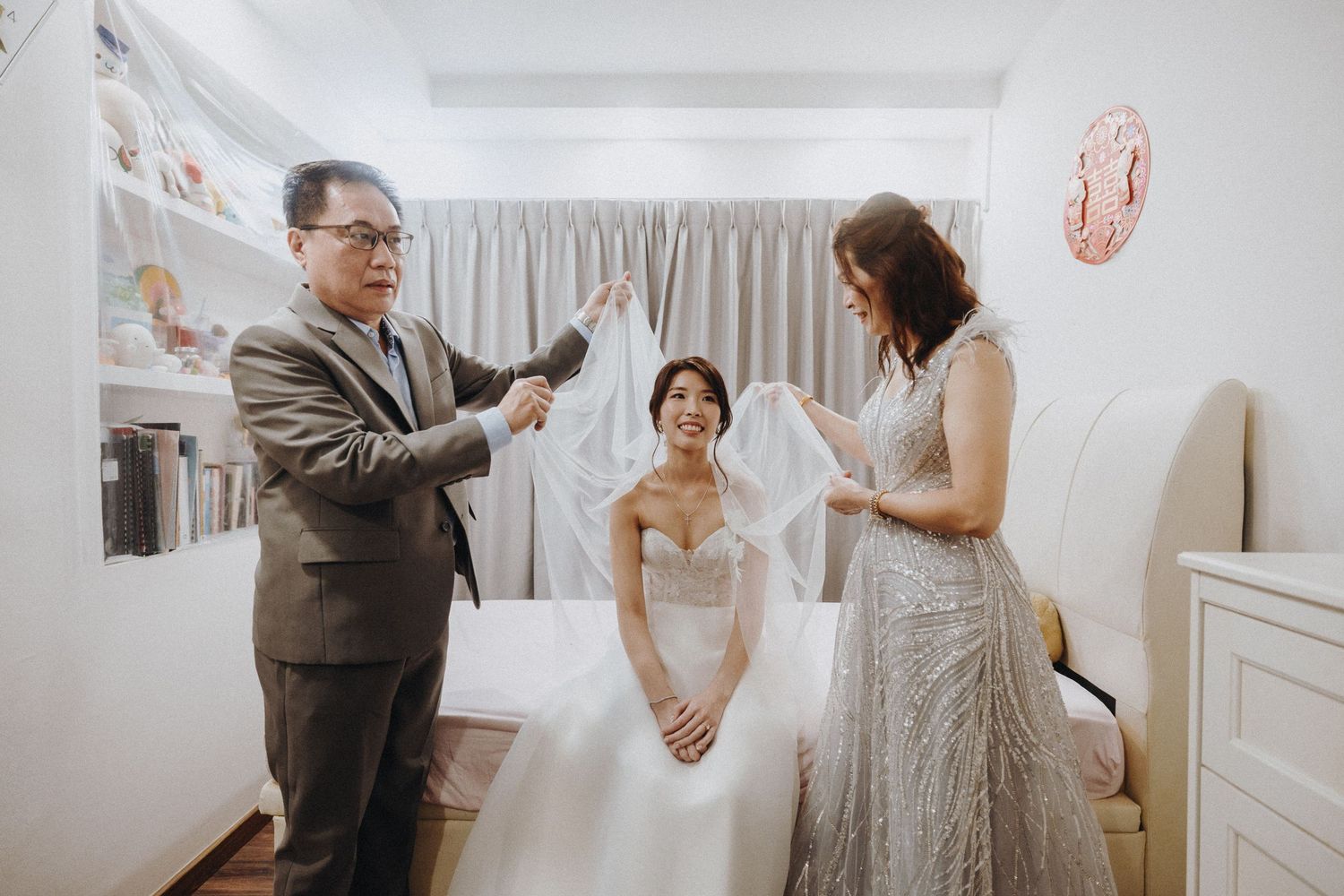 Wedding party laughs and dances together during celebration in bright white room with festive decorations.
