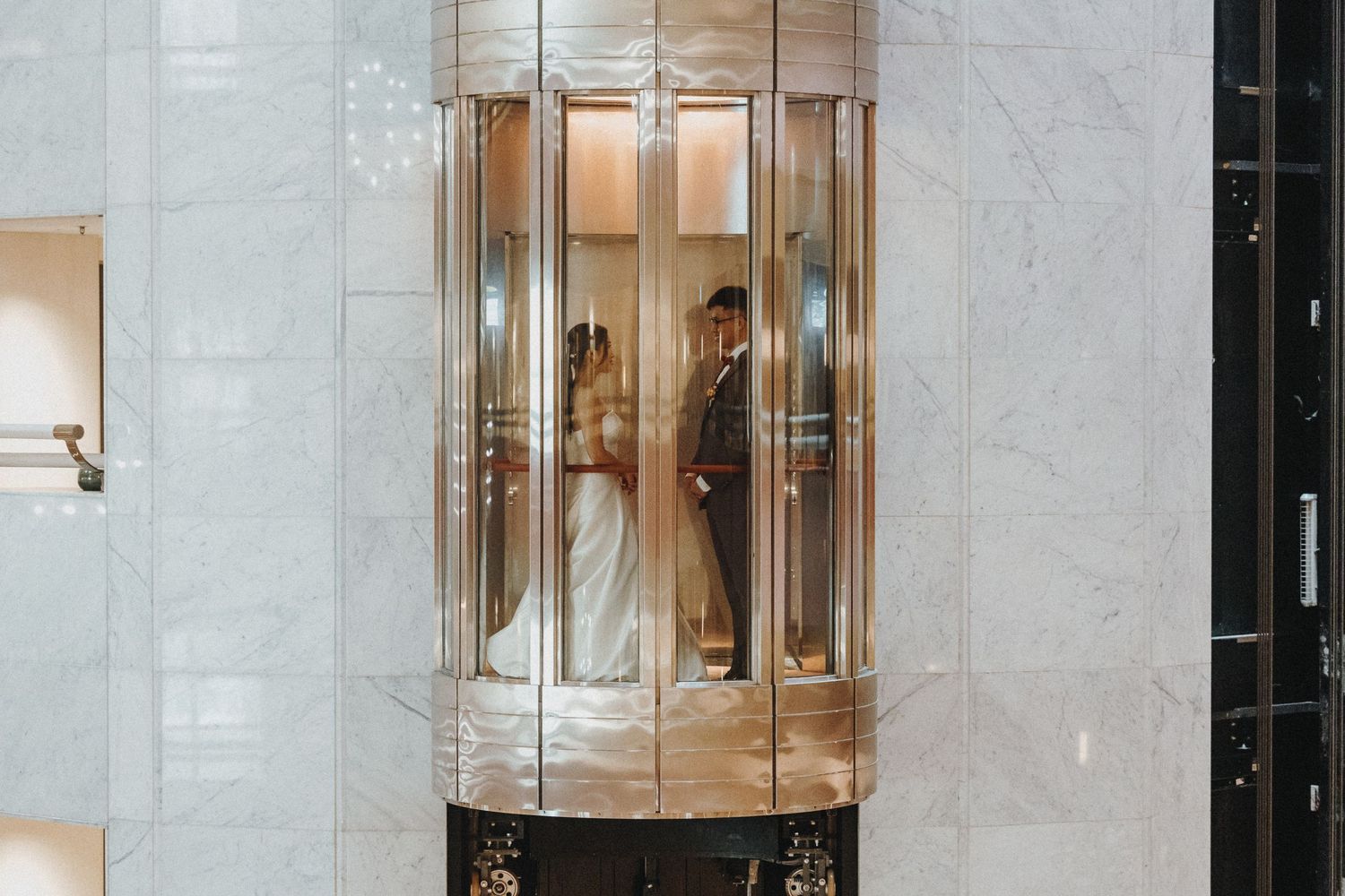 Illuminated vertical glass display cases in a row showcase items along a white tiled wall.