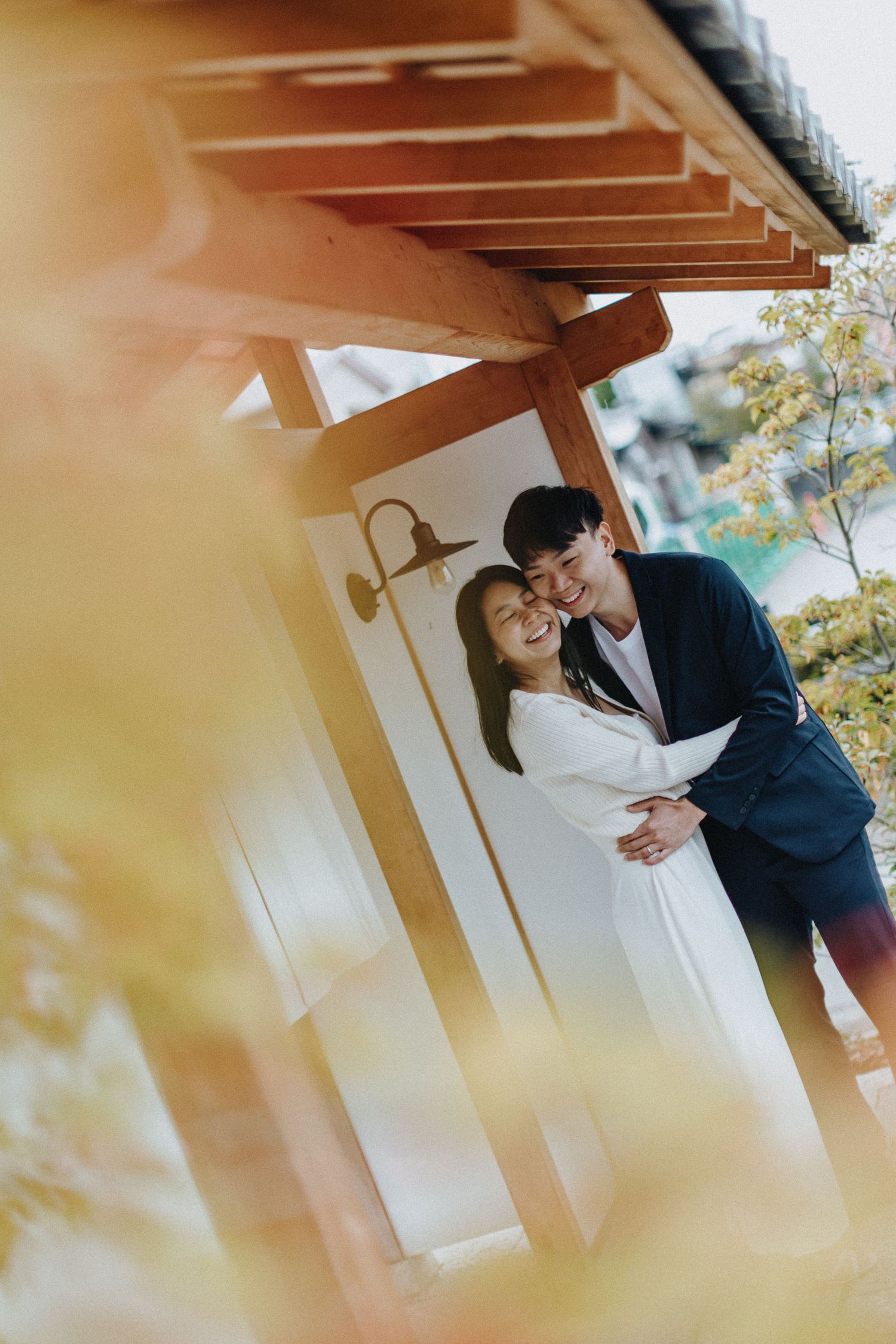 A tender romantic moment captured under warm wooden beams and natural lighting.