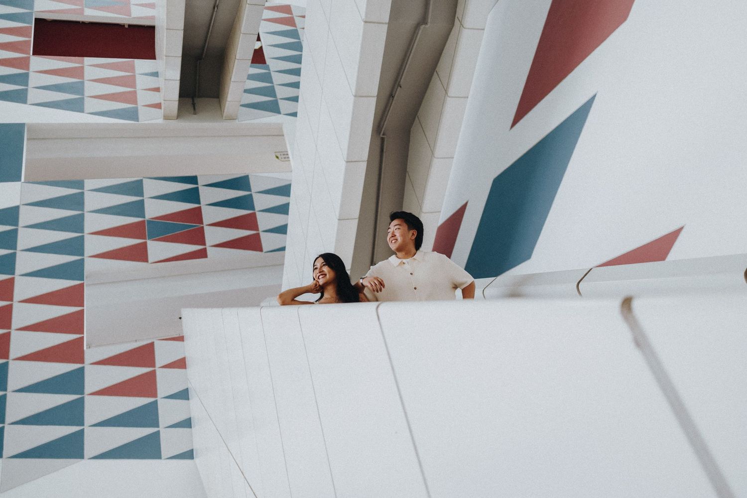 Modern architectural view with geometric patterns and people at viewing balcony.