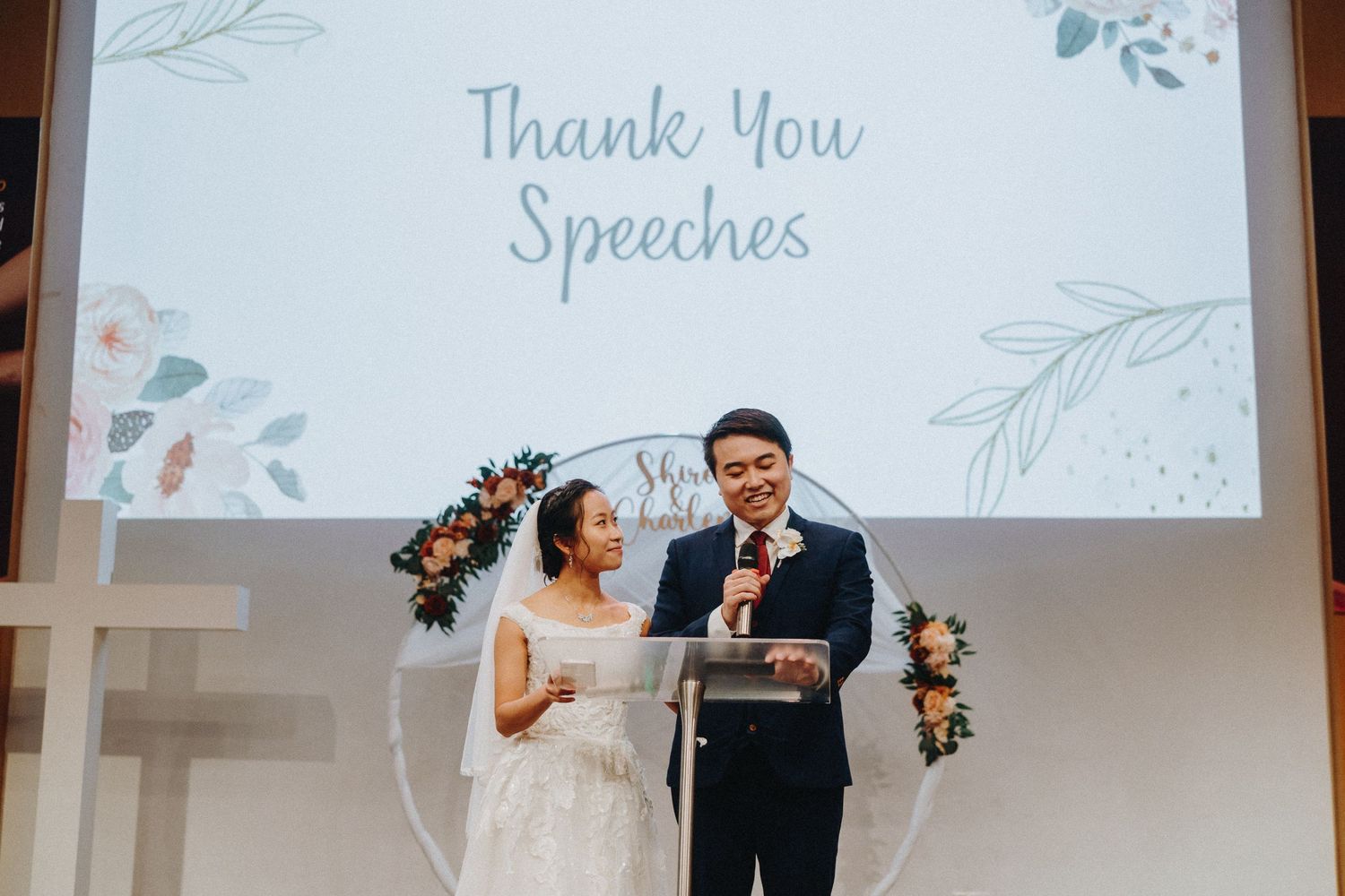Wedding ceremony projection screen showing floral decorations and text.