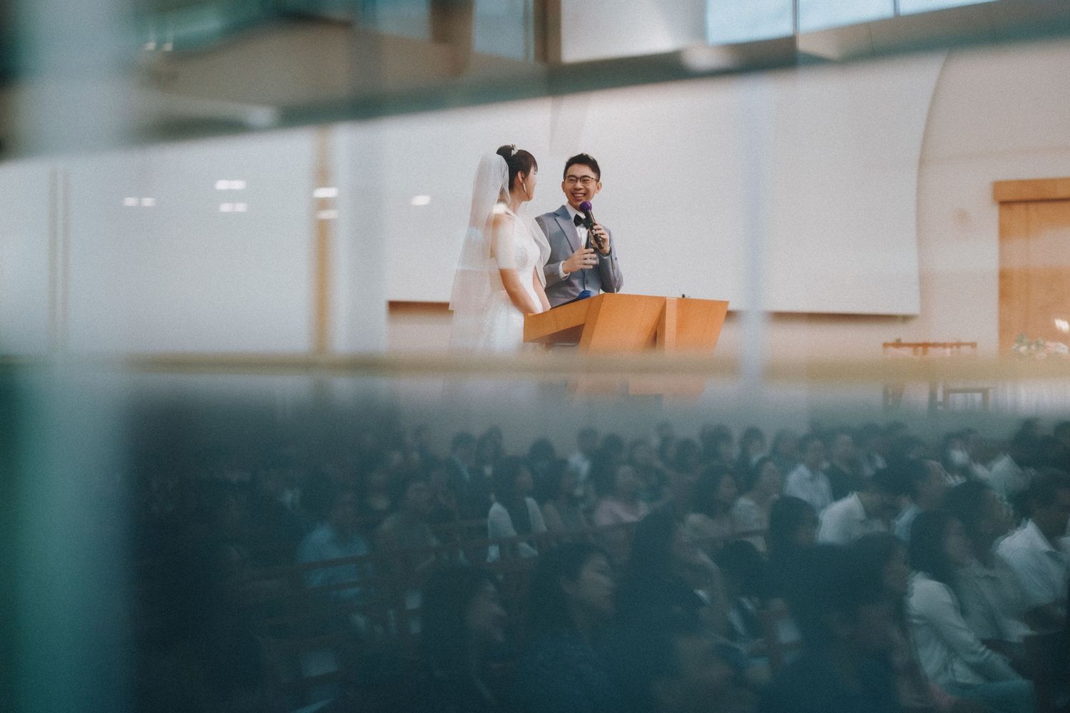 Wide panoramic shot of a wedding ceremony in a modern church setting.