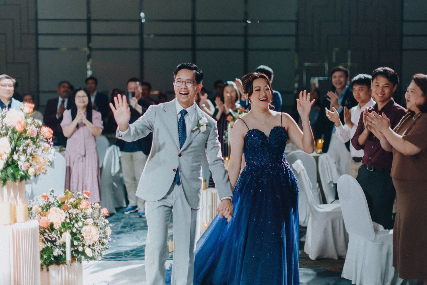 Wedding party members in navy and gray attire celebrating during reception.