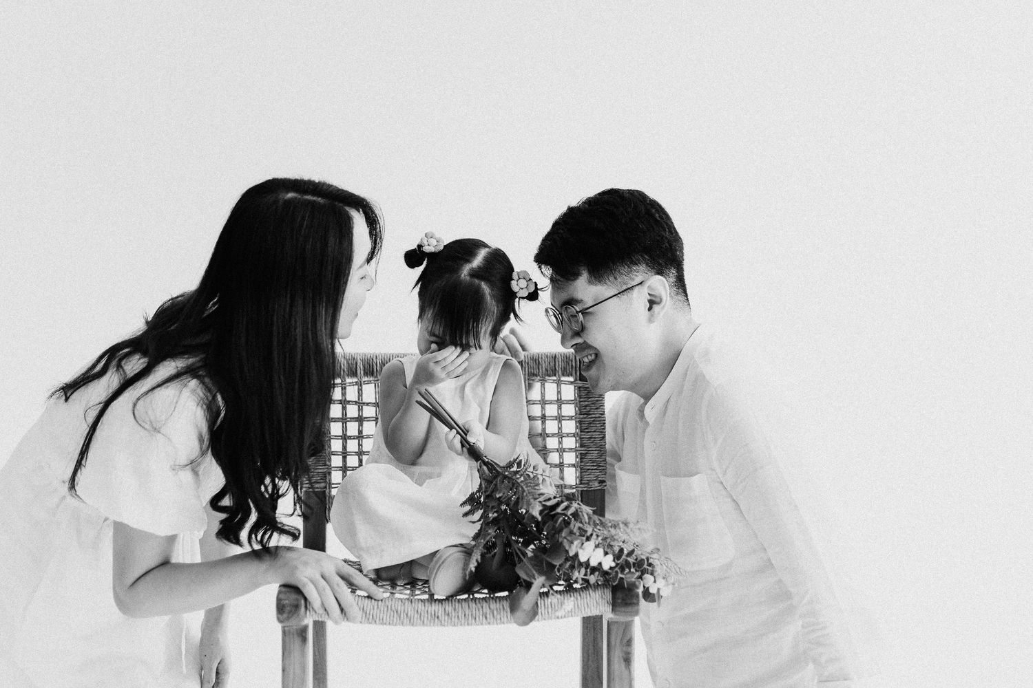 Black and white photo of family members gathered around flowers in an intimate moment.