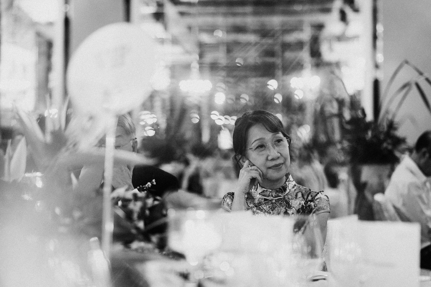 Soft focus black and white photo capturing intimate wedding reception moments.