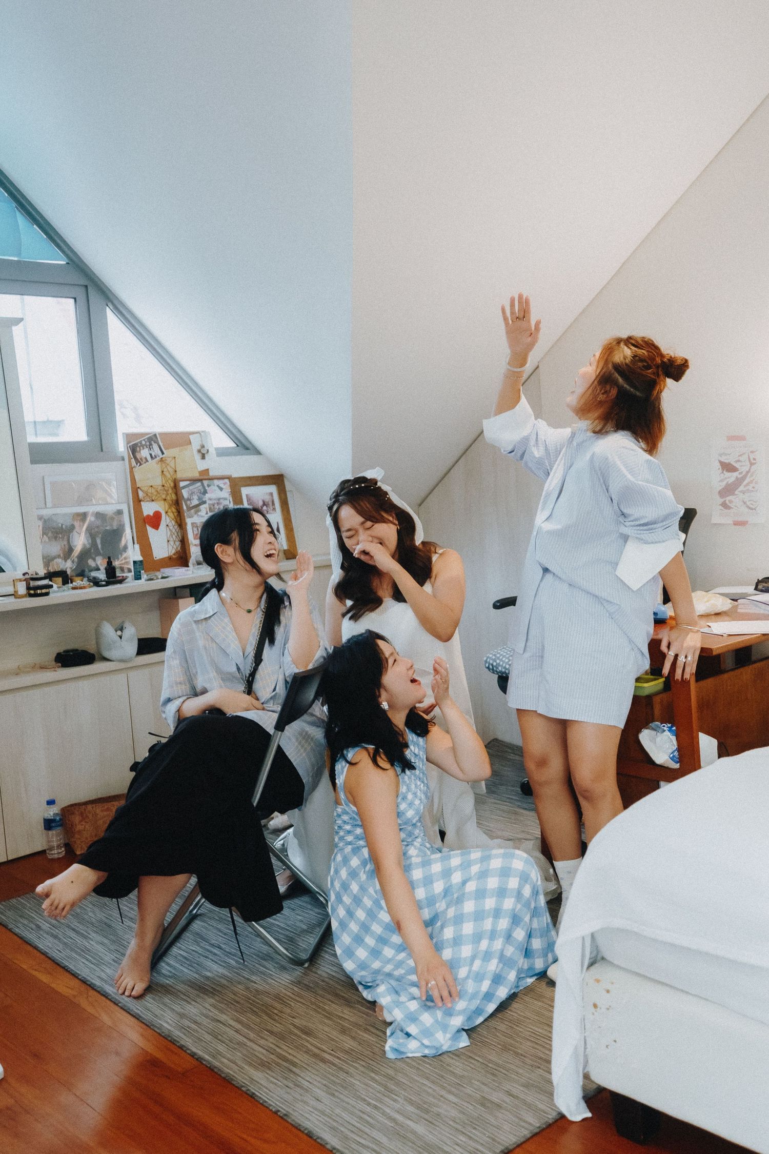 A cheerful group of friends having fun and laughing together in an attic-style room.