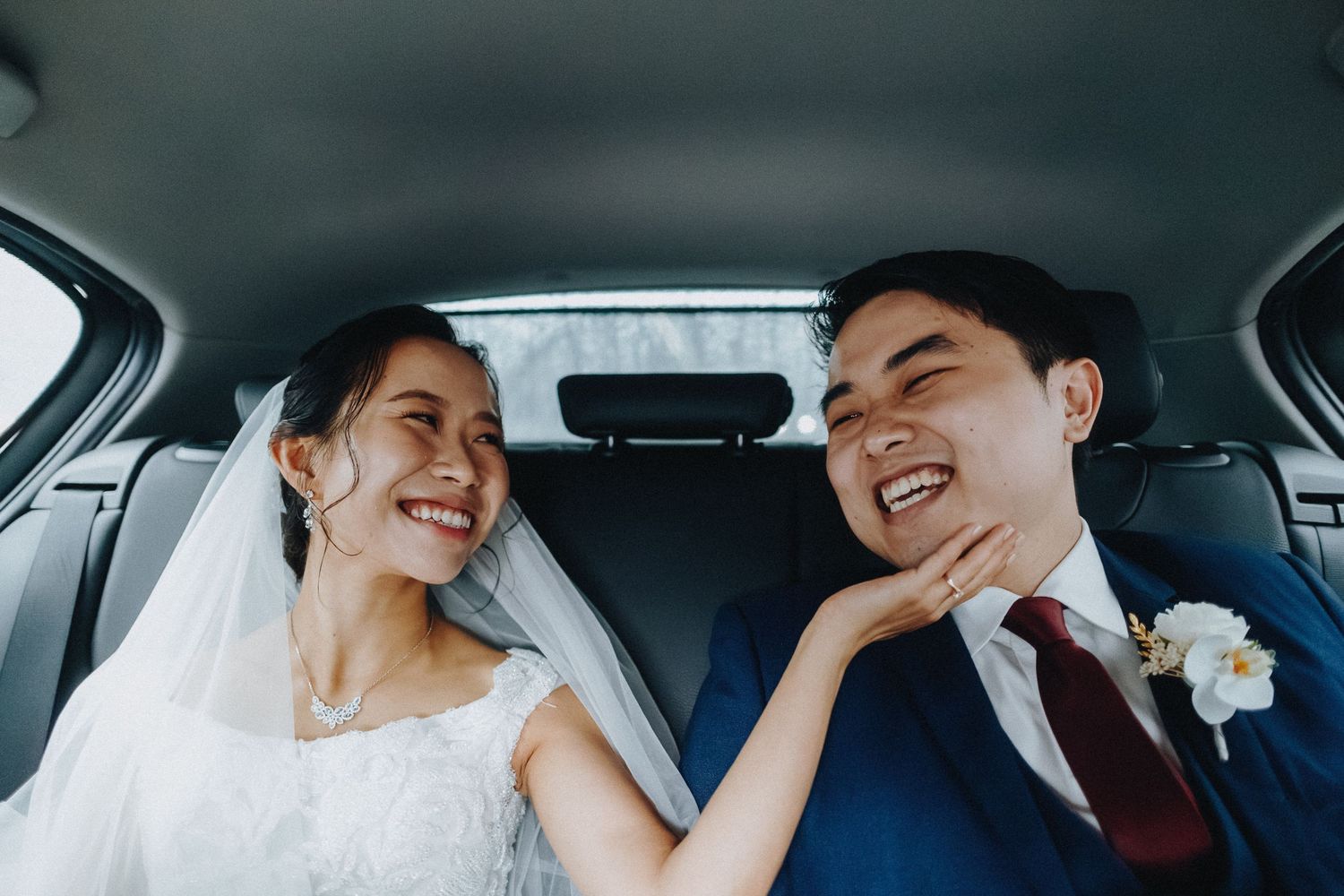 A joyful couple sharing candid moments together while sitting in a car.