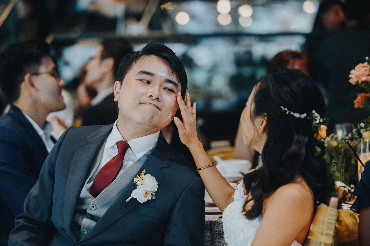 A tender moment between newlyweds during their wedding reception.