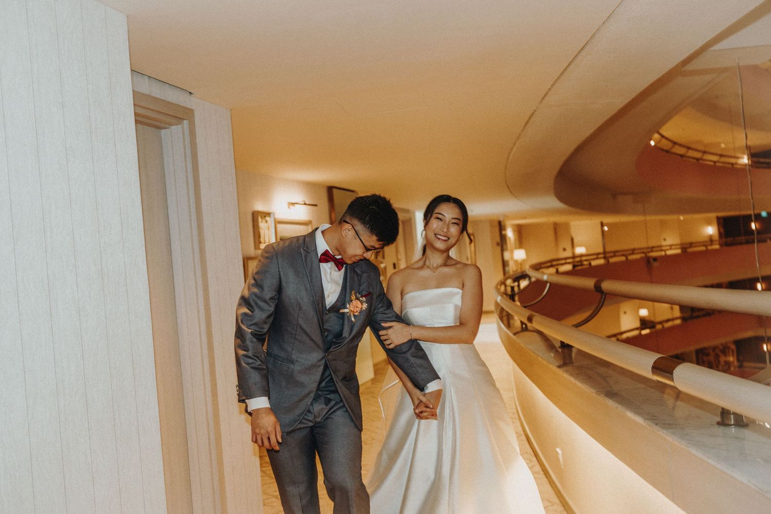 Wedding party walking down a hallway in formal attire for a celebration.
