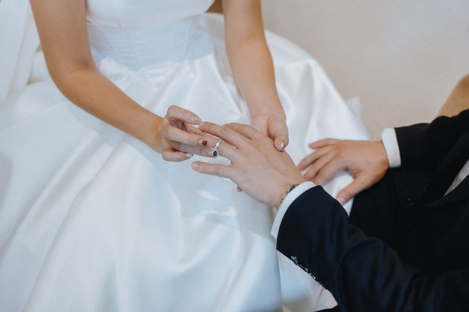 Groom placing a wedding ring on the bride's finger during the ring exchange ceremony.
