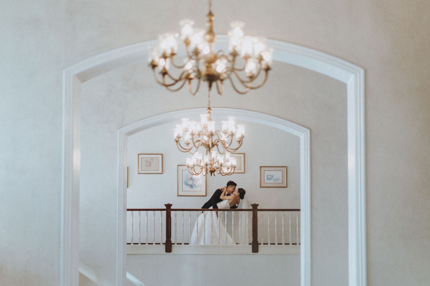 Elegant wedding venue interior with crystal chandeliers and decorative ornate staircase balustrade.