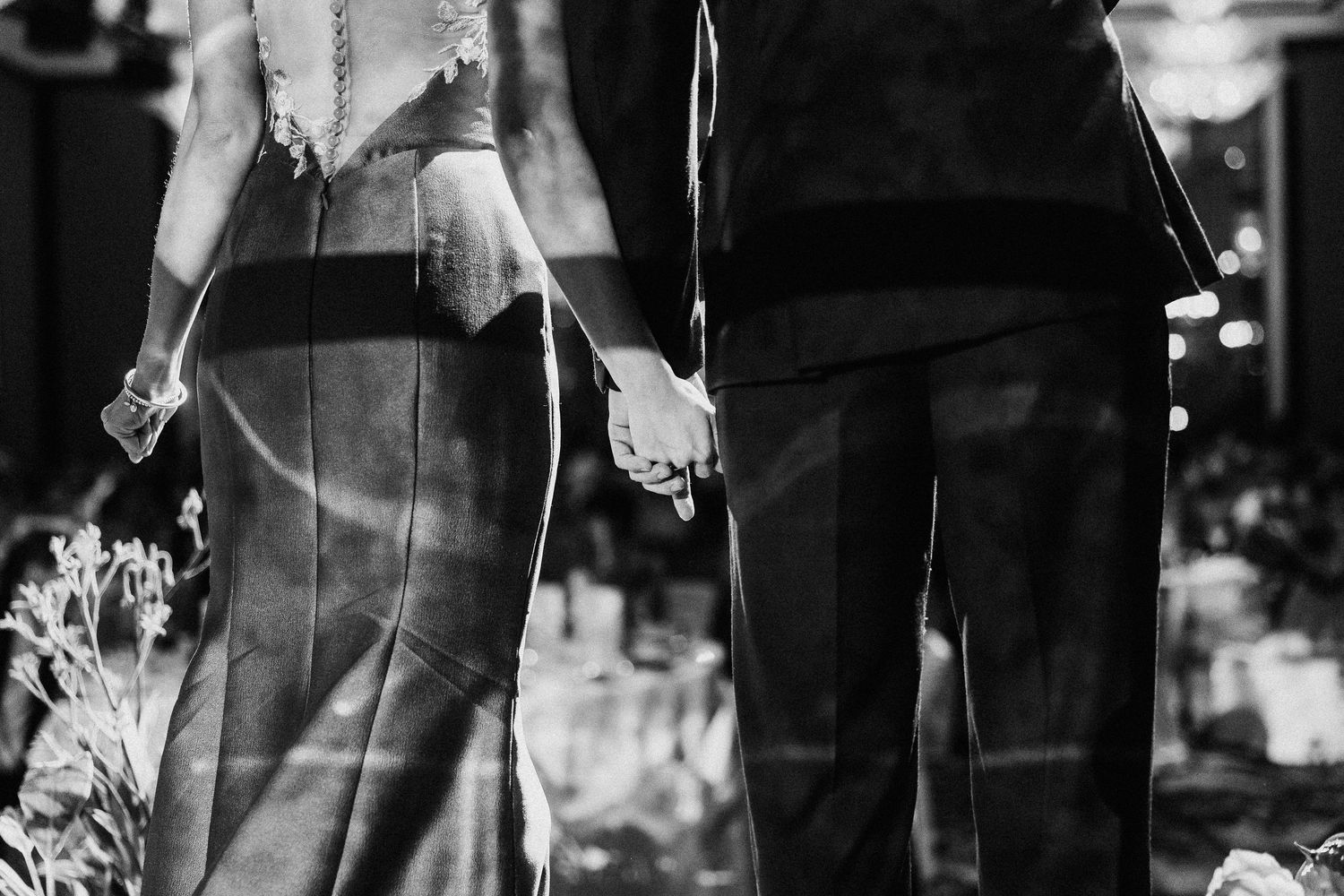 Black and white candid shot of wedding guests at formal reception.