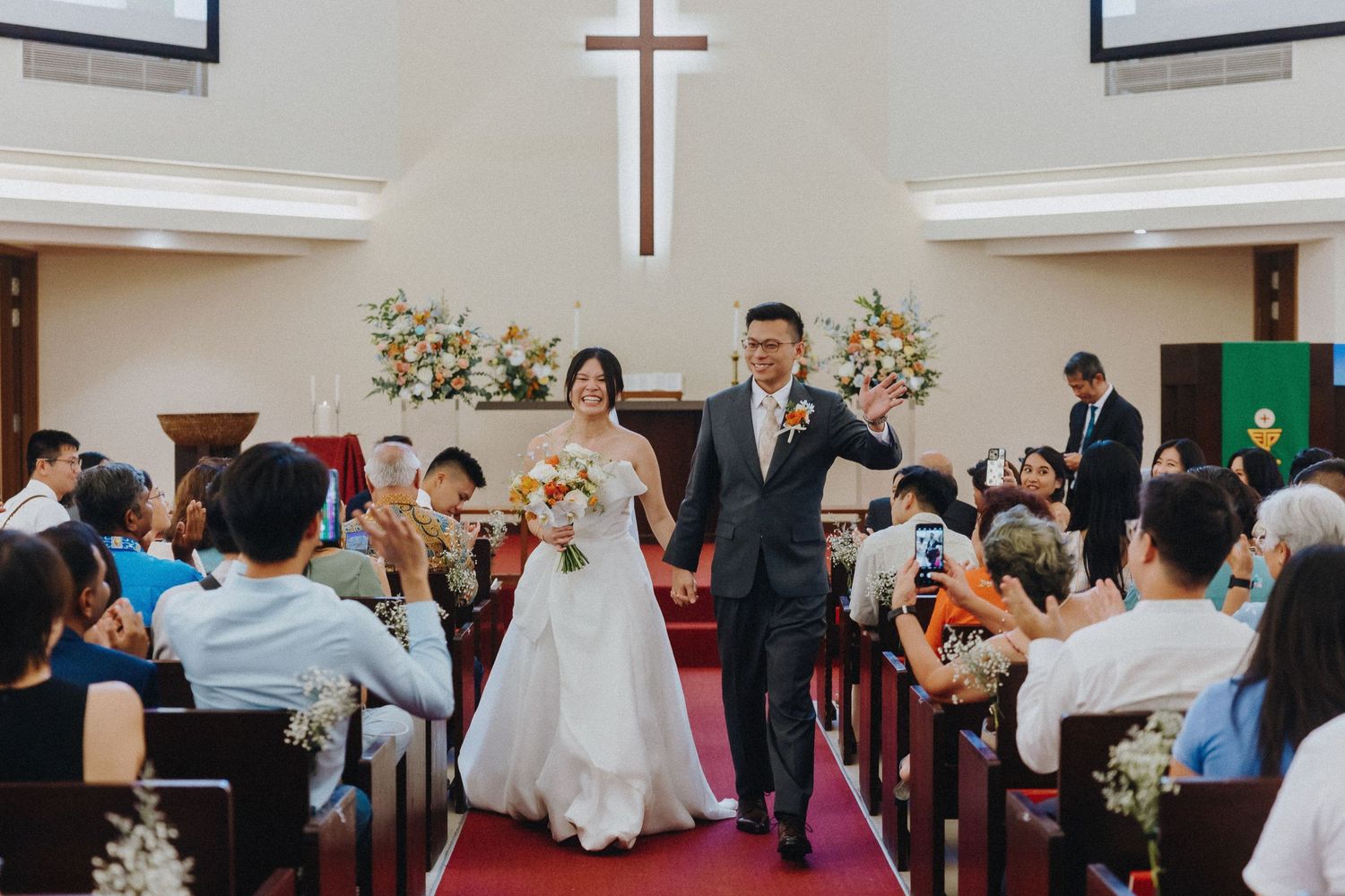 Wedding ceremony guests capture memories with smartphones and cameras as they celebrate the festive occasion.