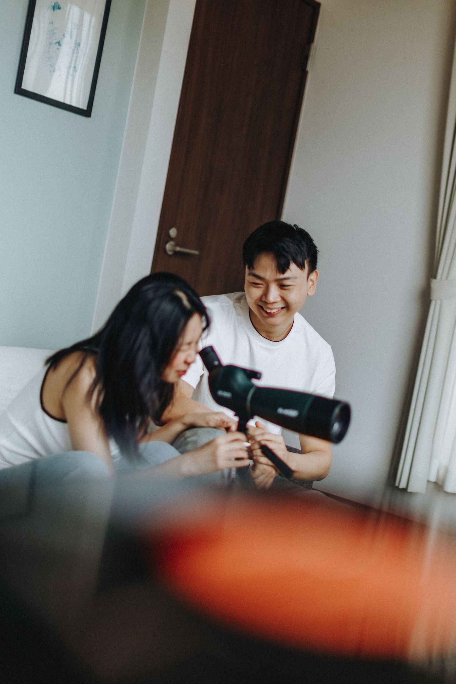 Playful indoor photography session with camera equipment in natural light.