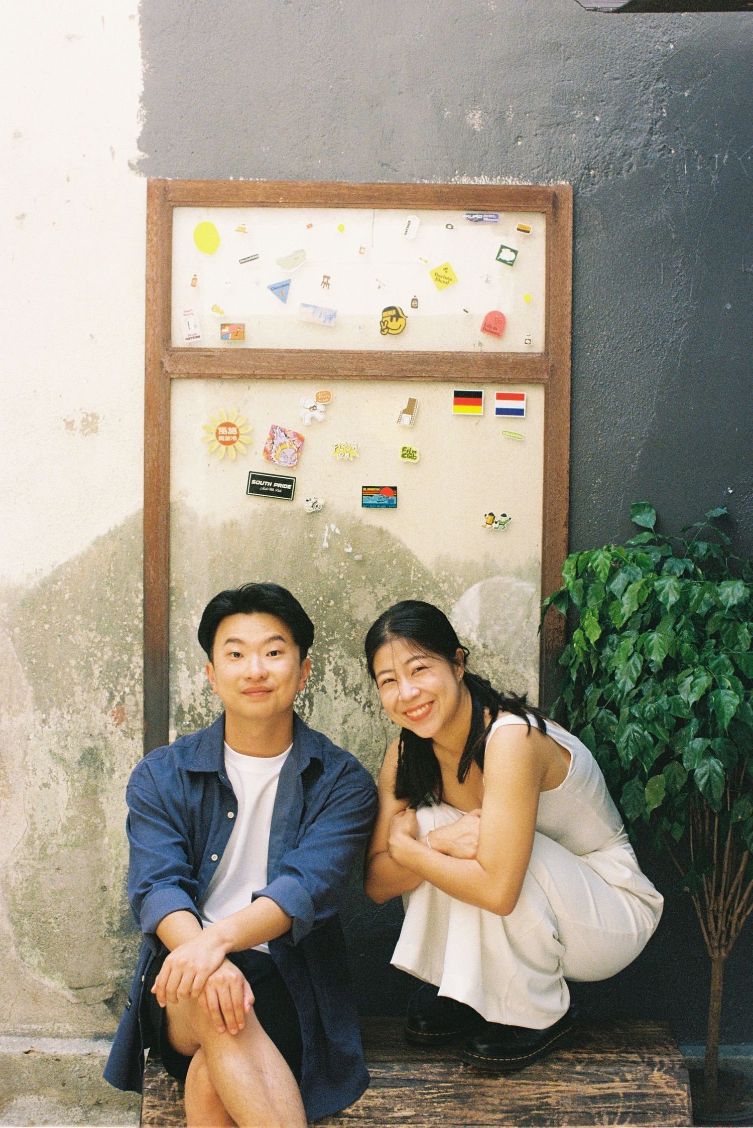A series of candid photographs displayed in wooden frames showing intimate moments against a textured wall background.