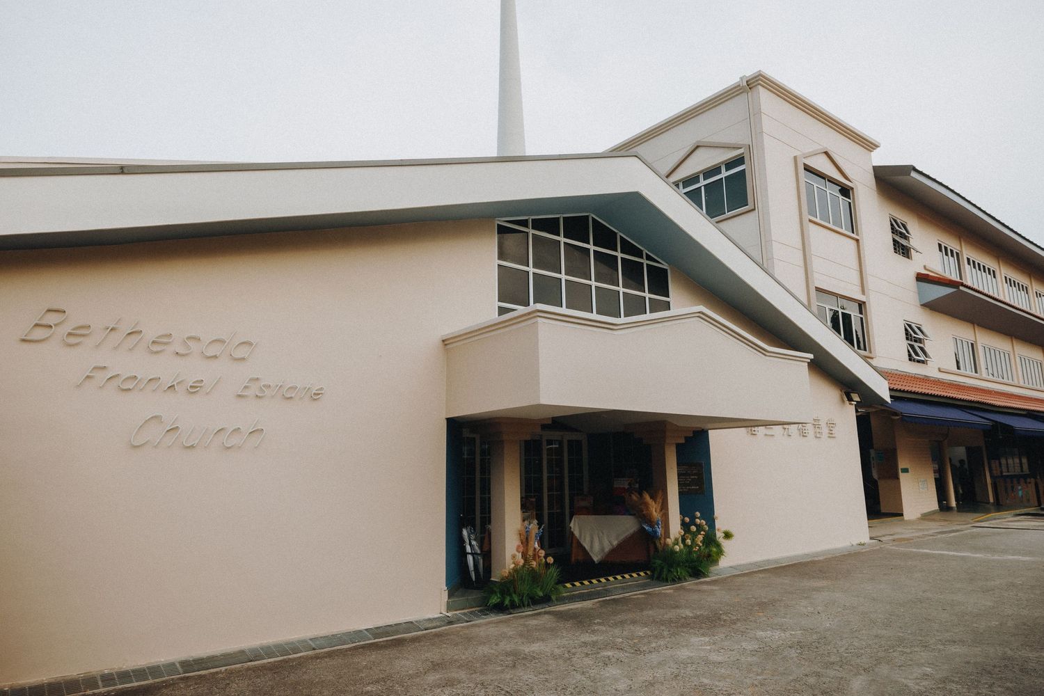 Modern beige church or community center building exterior with curved architectural features.