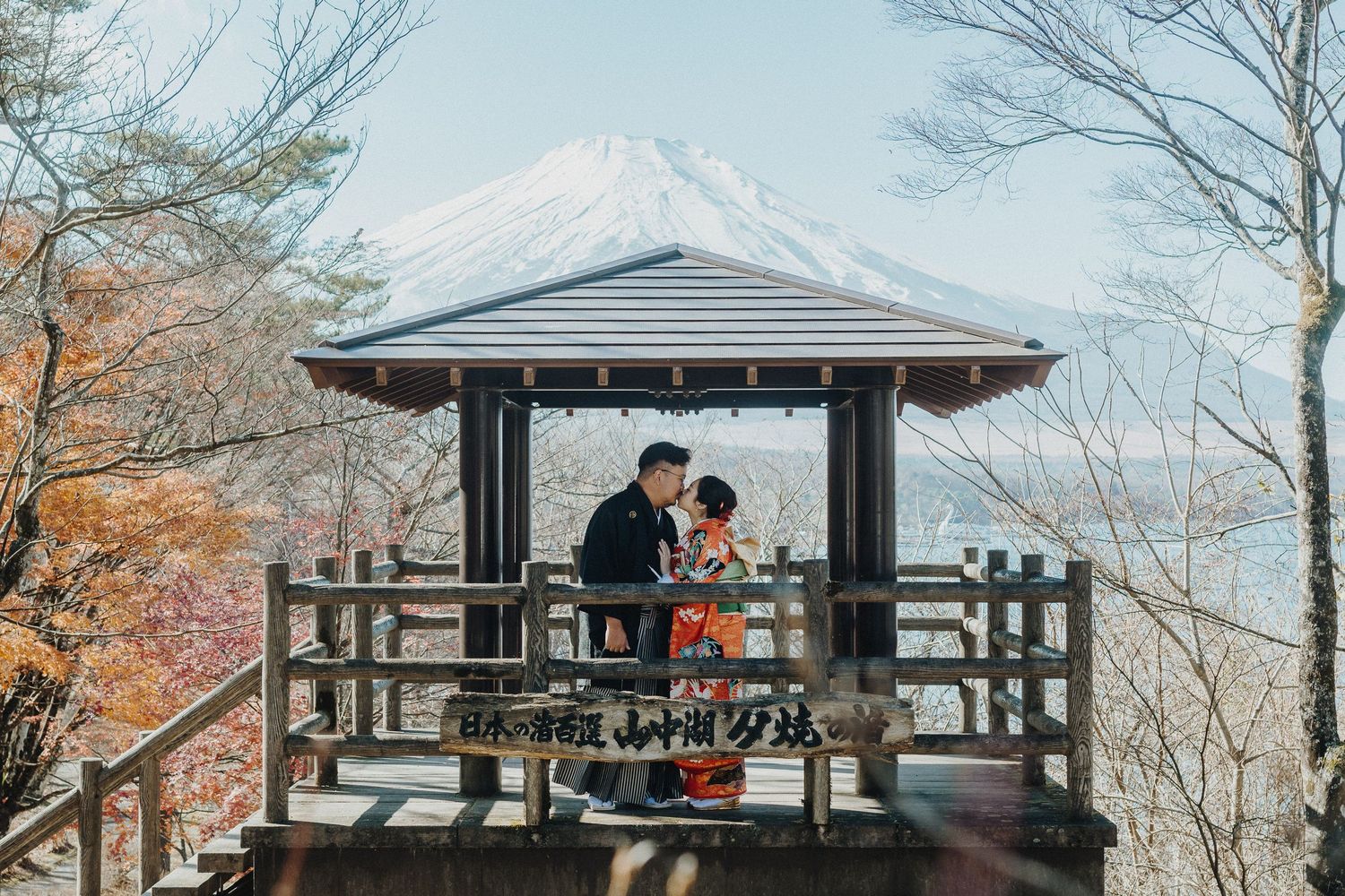Traditional Japanese gazebo overlooks Mount Fuji with autumn foliage in the foreground.