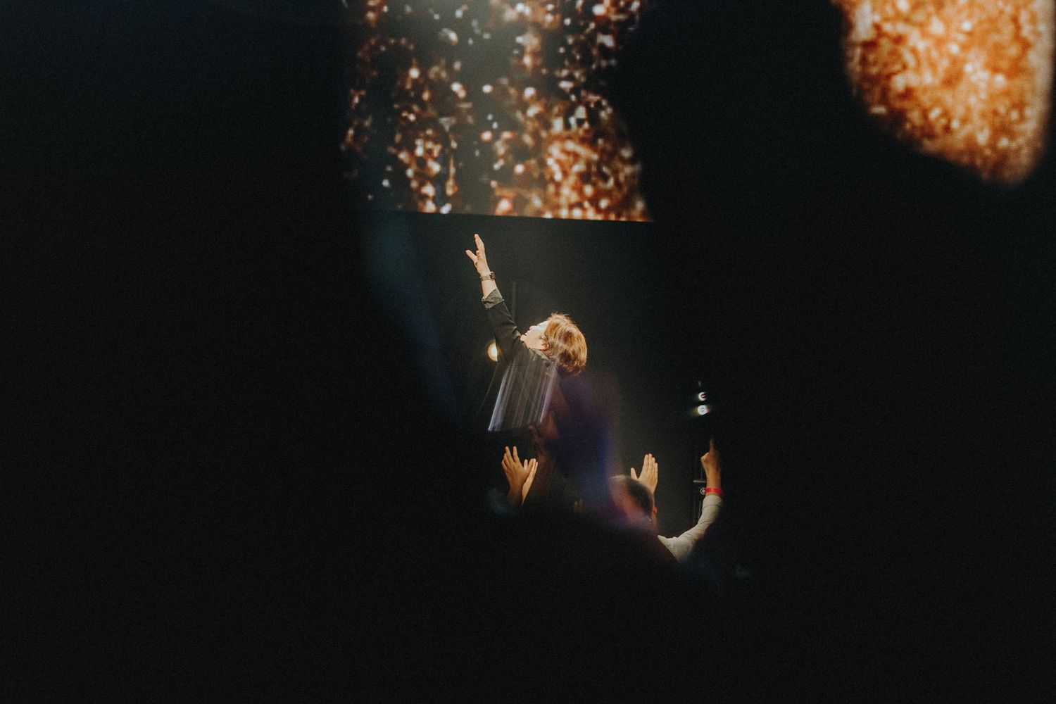 Orange sparks and firework effects illuminate a dark concert stage during live performance.