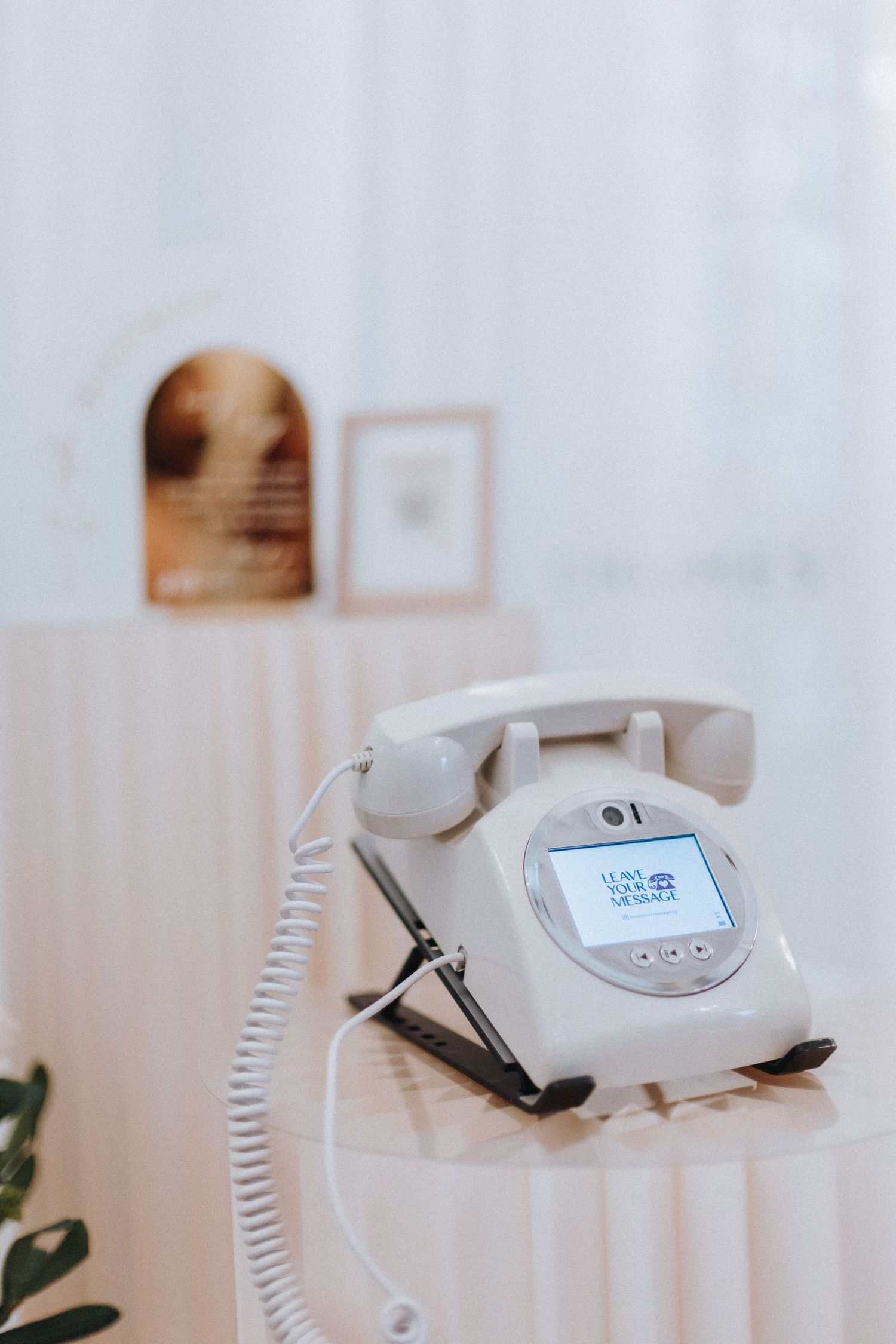 White retro telephone with QR code display on elegant table at a wedding venue.