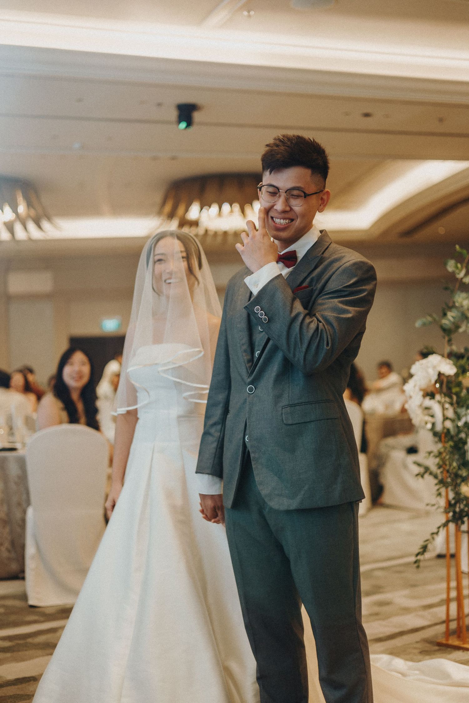 A joyful moment during a wedding ceremony in an elegant hotel ballroom.