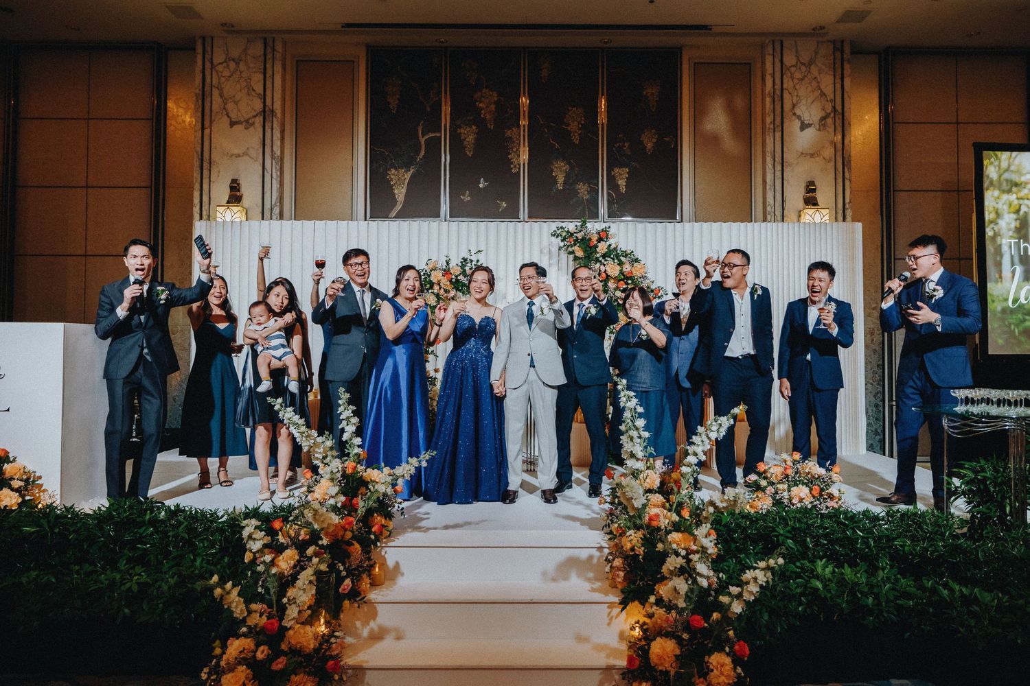 Outdoor wedding venue decorated with lush peach and orange floral arrangements.