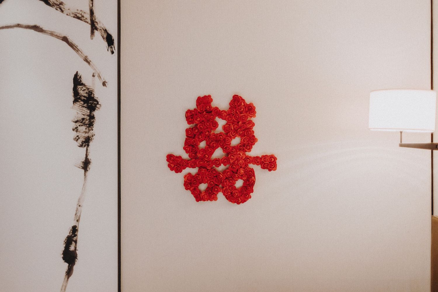 Red paper flowers and vines create an artistic border pattern against a white background.