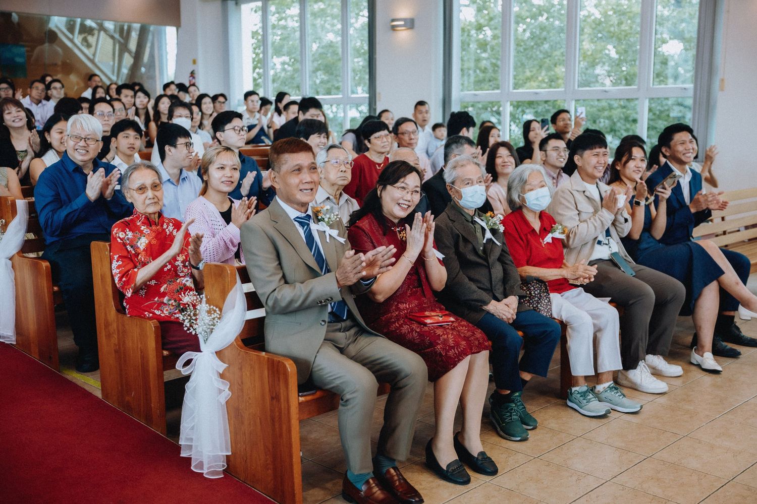 Wedding guests applaud and celebrate during church wedding ceremony.
