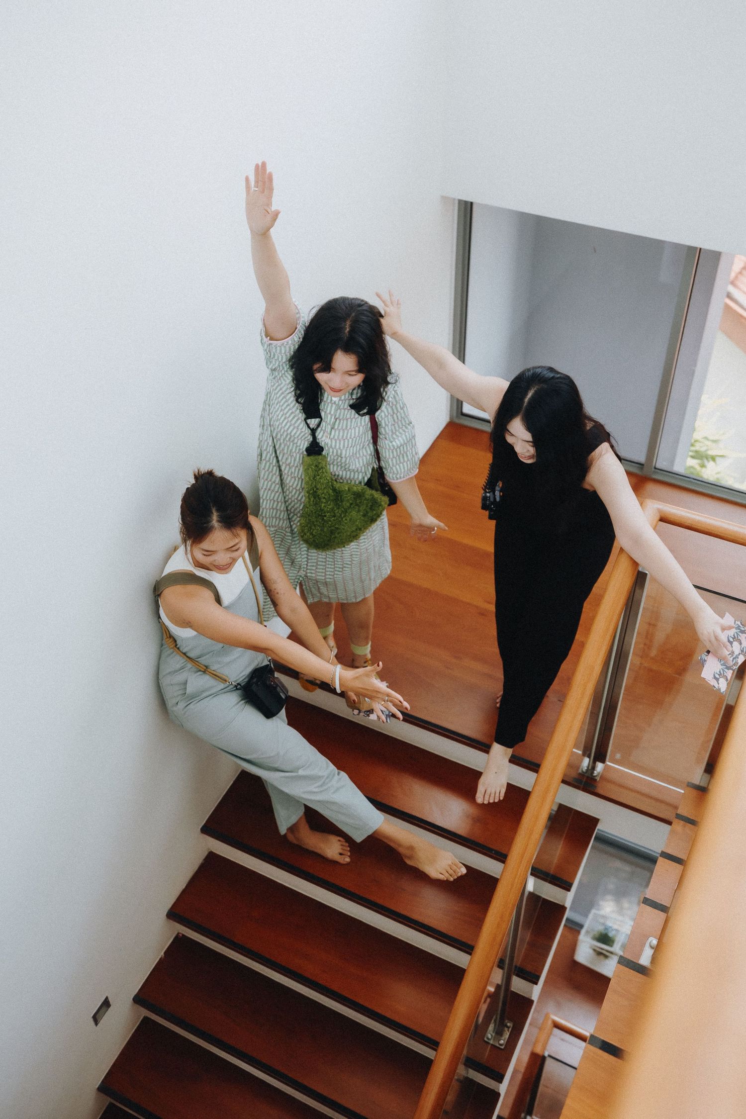 A playful series of poses on wooden stairs with a guest book and pen.