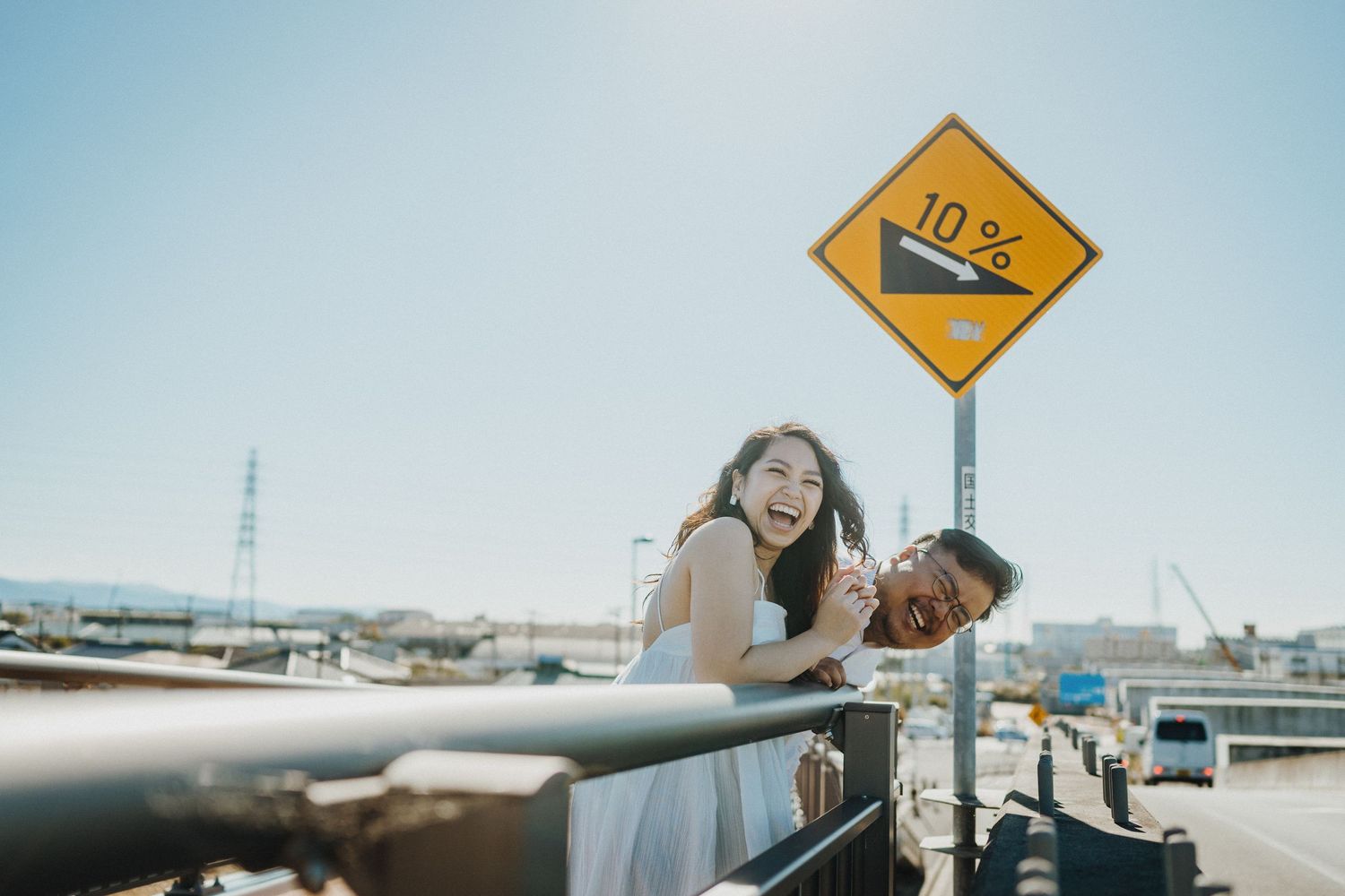 Playful moment by a road sign with Mount Fuji visible in the distance.