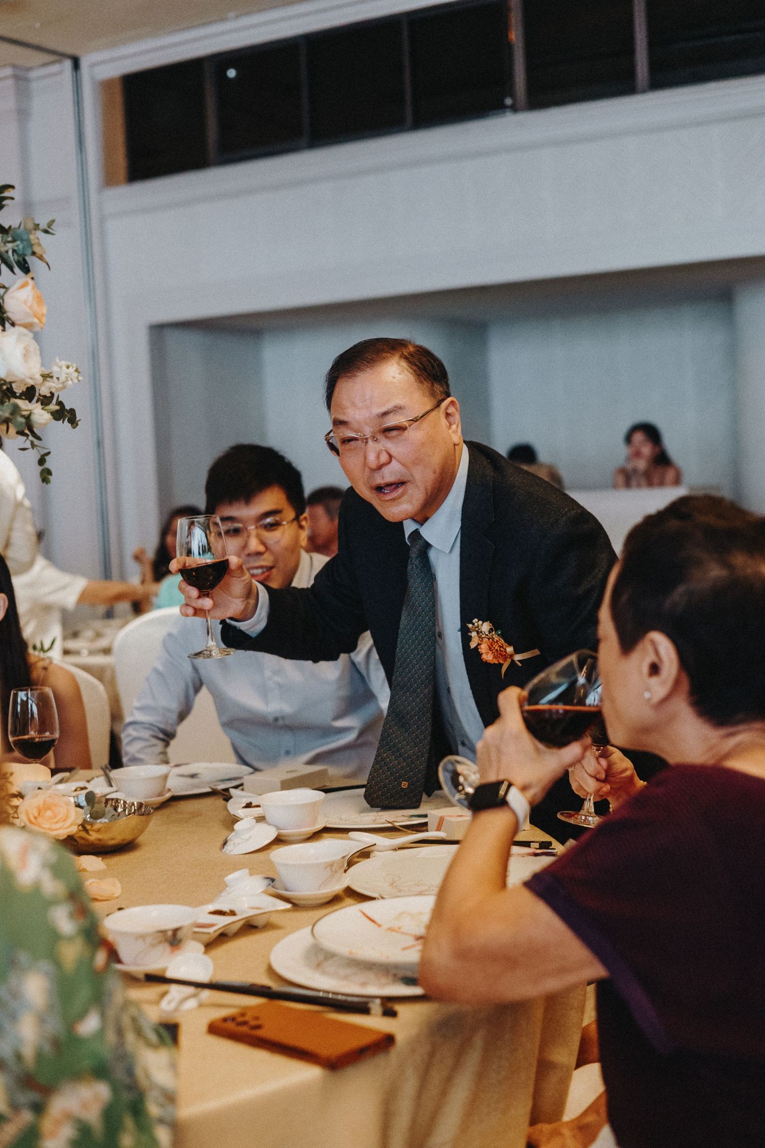 Guests gathered around dining tables at an elegant wedding reception.