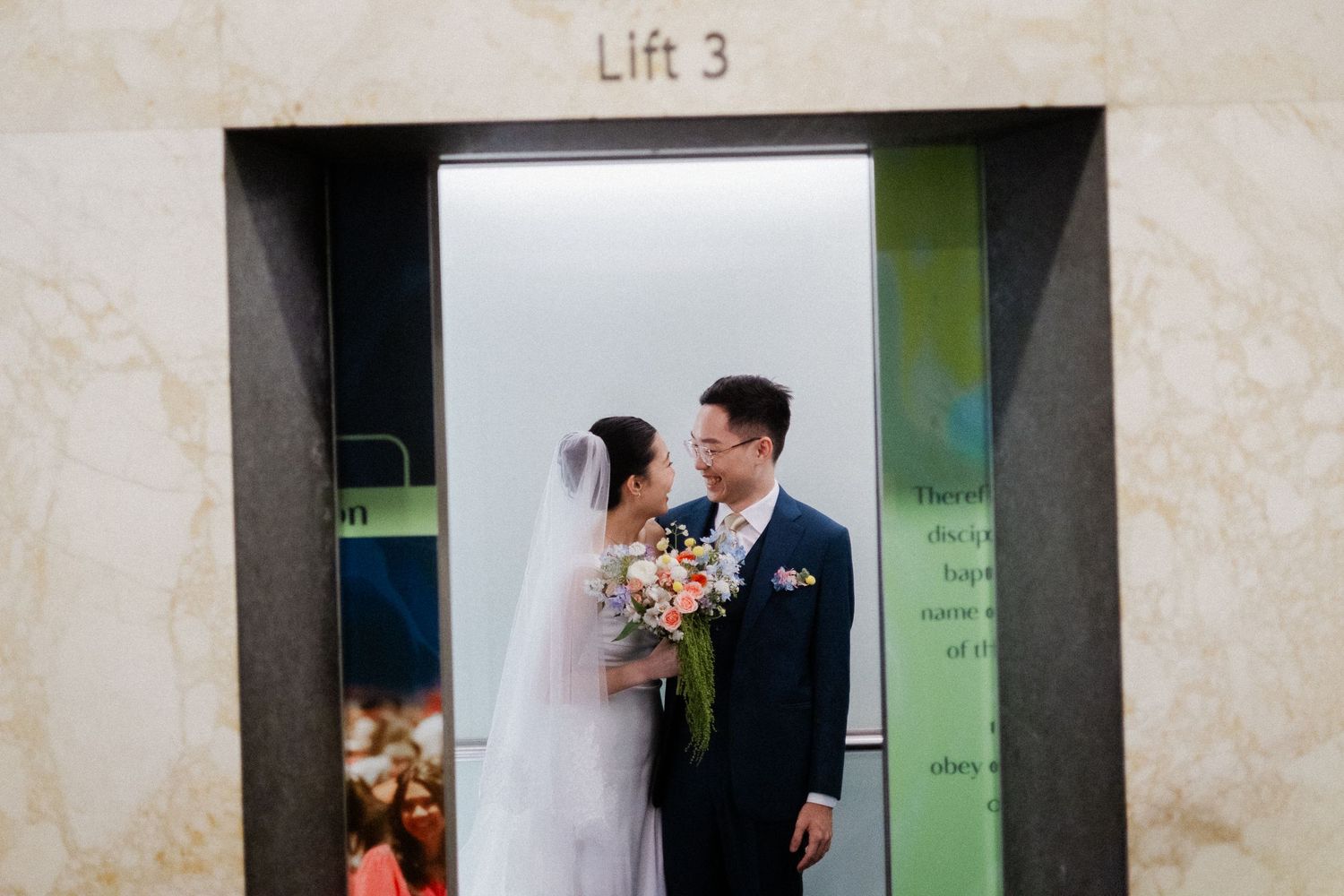 A bride and groom share a romantic moment in front of Lift 3, bride holding a colorful bouquet in wedding attire.