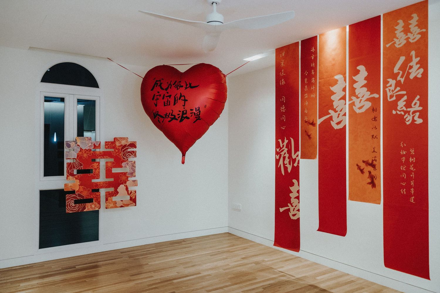 Red and white decorative room with festive heart-shaped balloon and Chinese New Year wall decorations.
