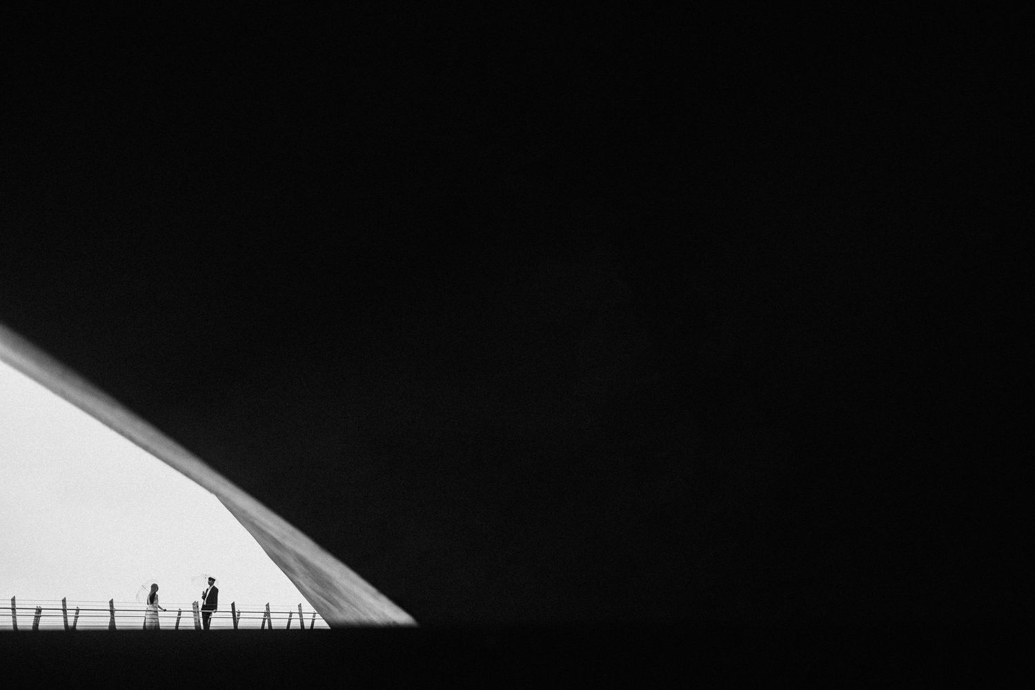 Minimalist black and white silhouette of people against geometric architectural shapes.