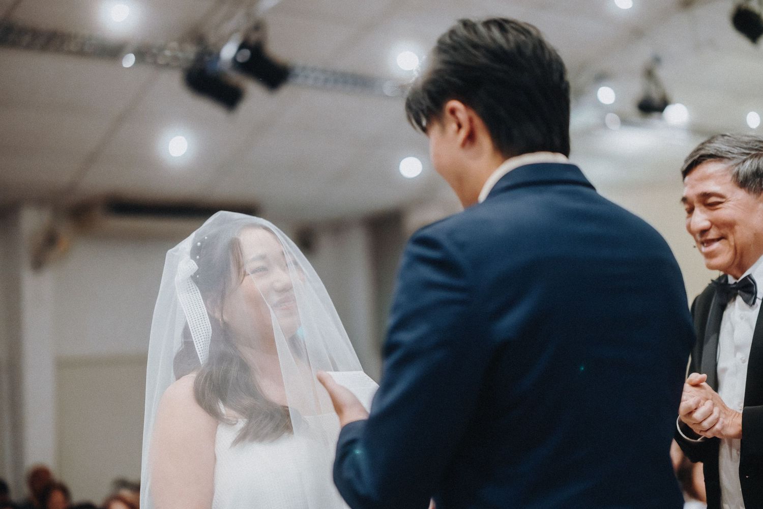 Wedding ceremony taking place in a brightly lit indoor venue.