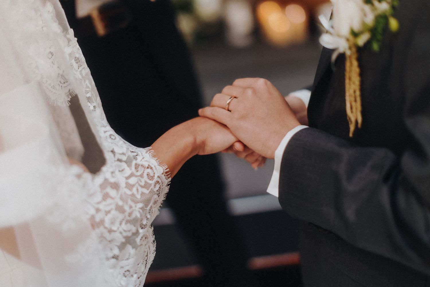 Wedding guests raise their glasses in a celebratory toast at an elegant indoor reception.