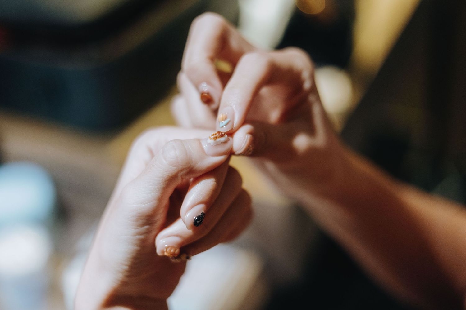 Close-up of hands exchanging a gold ring during a wedding ceremony.