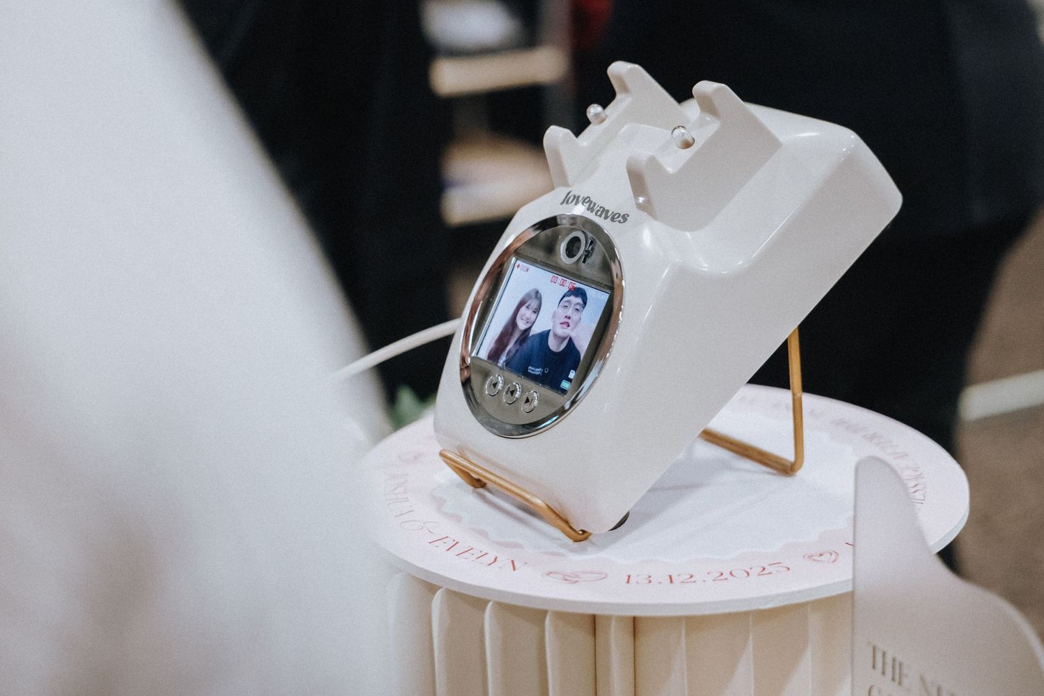 A white charging dock displays a digital photo on a decorative table setting.