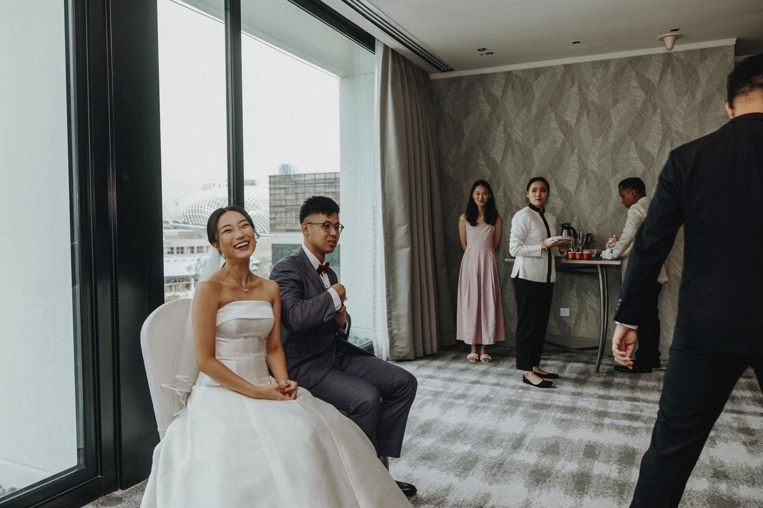 Contemporary hotel suite with large windows during wedding day preparations.