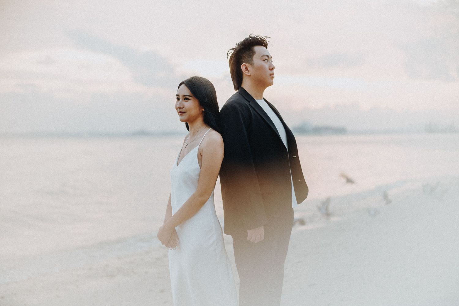 Couple having fun during sunset beach photoshoot.