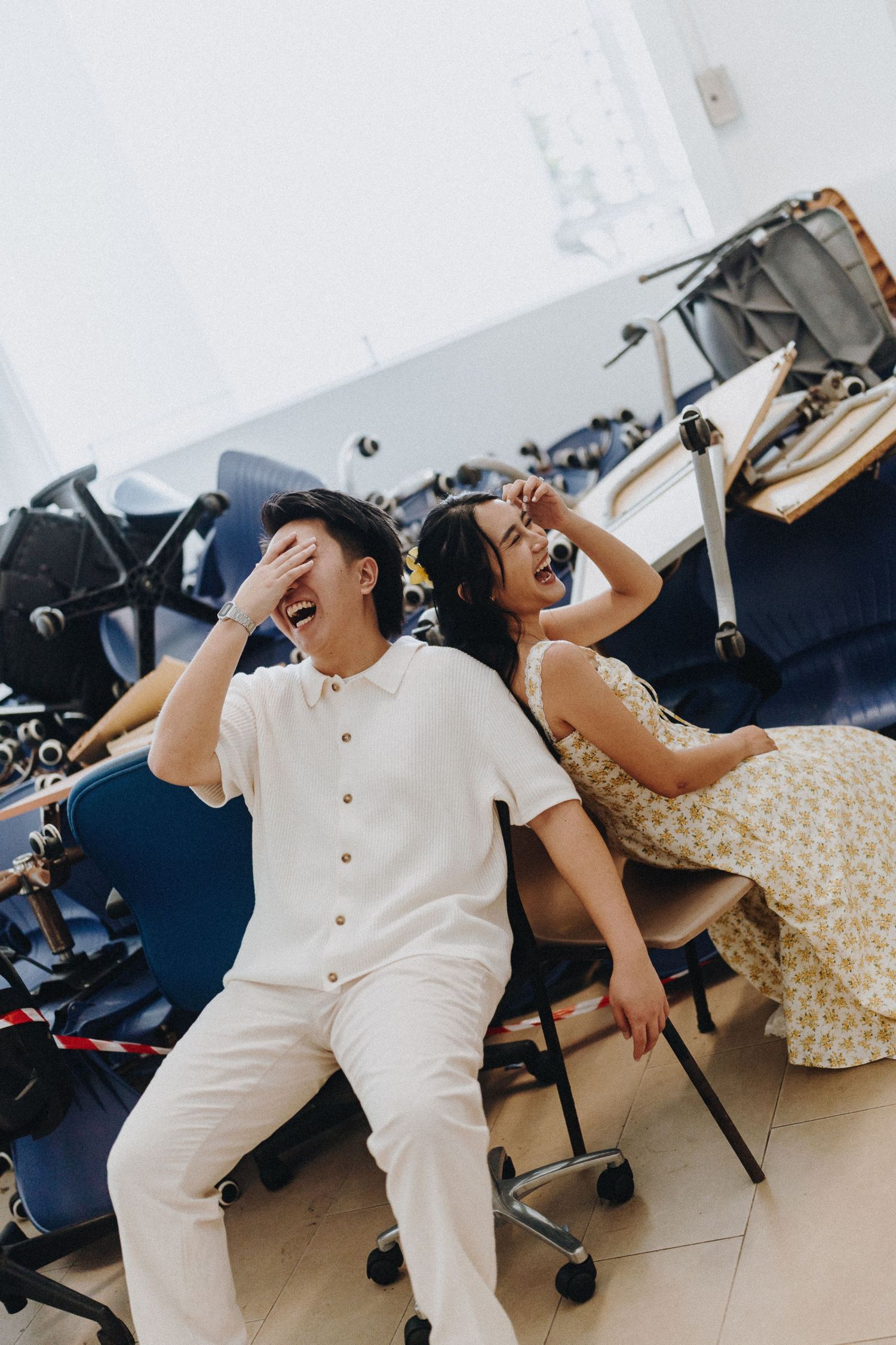 Candid moments captured of a couple laughing and having fun in a studio setting.