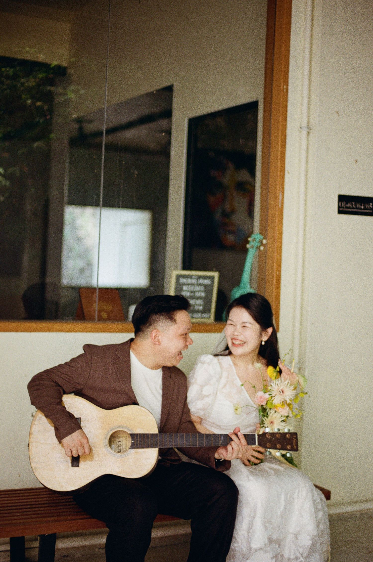 A romantic sequence of a couple sitting on a couch, with a guitar and flowers decorating an intimate indoor setting.