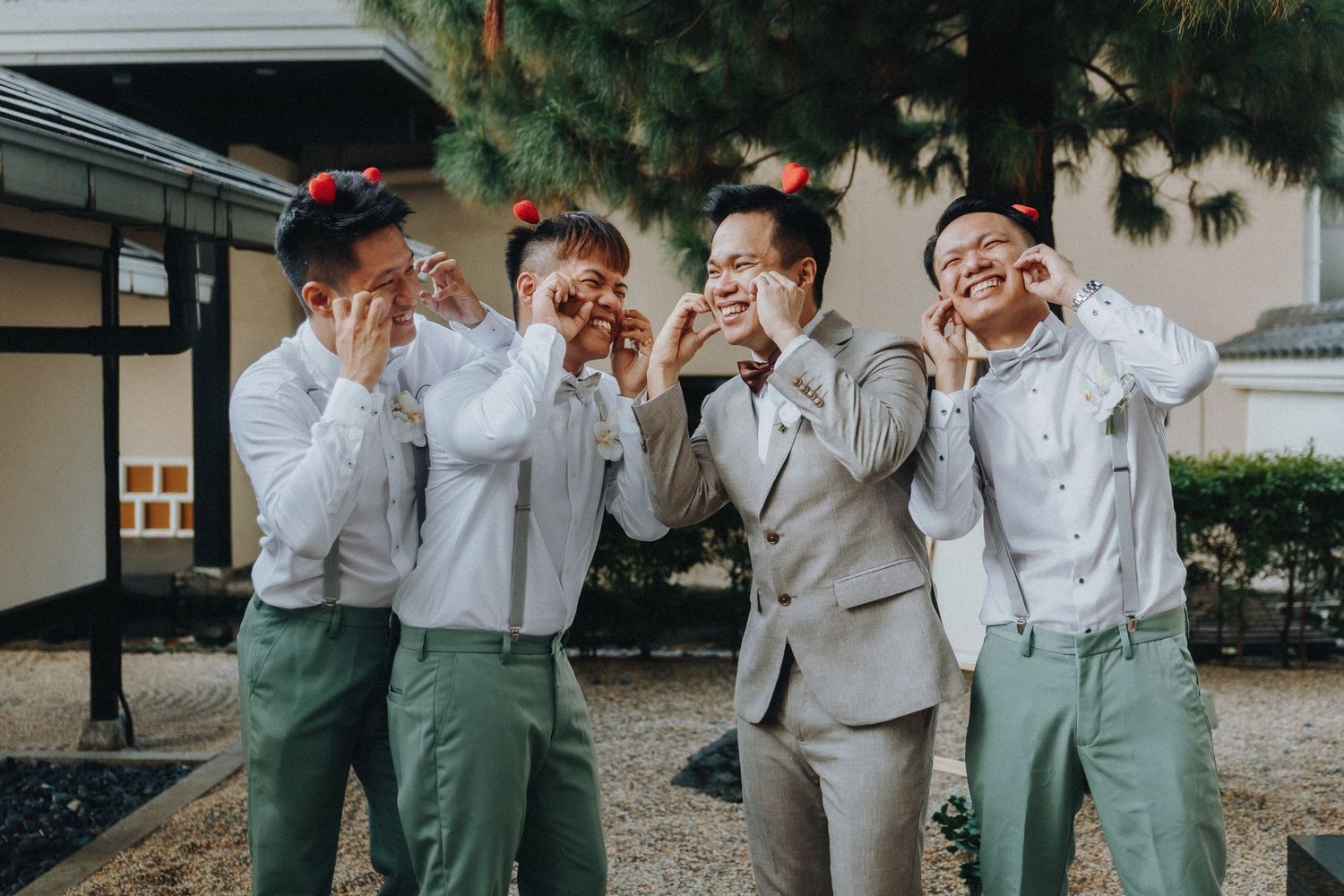 Wedding party members in matching outfits make silly expressions while posing together outdoors.