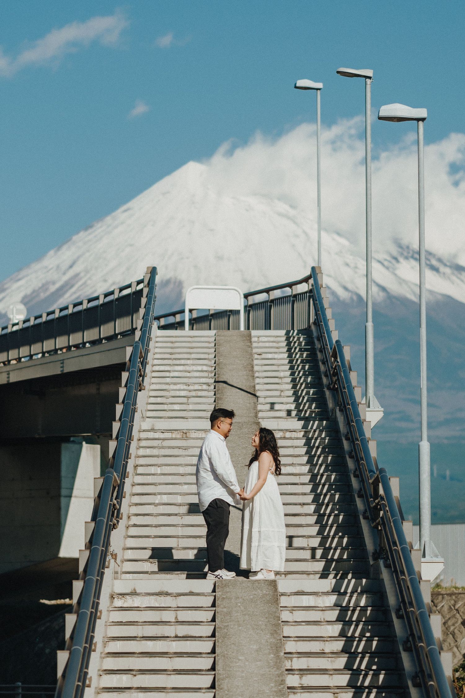 A series of concrete steps against a blue sky with Mount Fuji visible in the background.