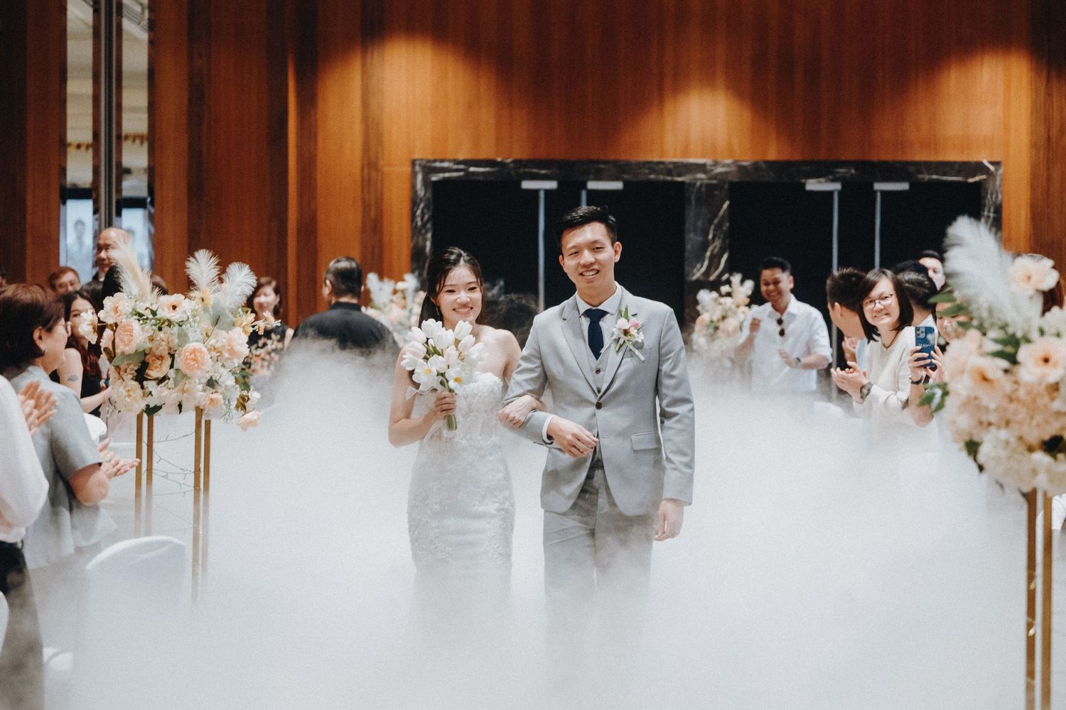 Wedding reception panorama in a wood-paneled banquet hall with soft lighting and decorative elements.