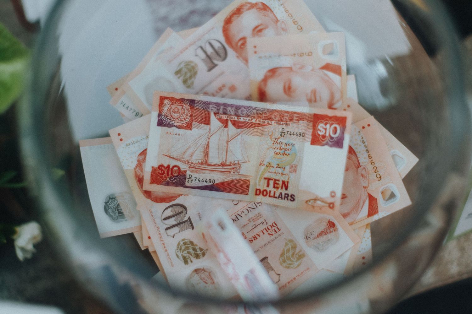 Stack of red and white Hong Kong currency banknotes shown close up.